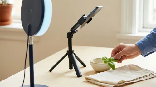 Phone tripod content production setup with ring light and flat-lay props illustrating social media strategy craft